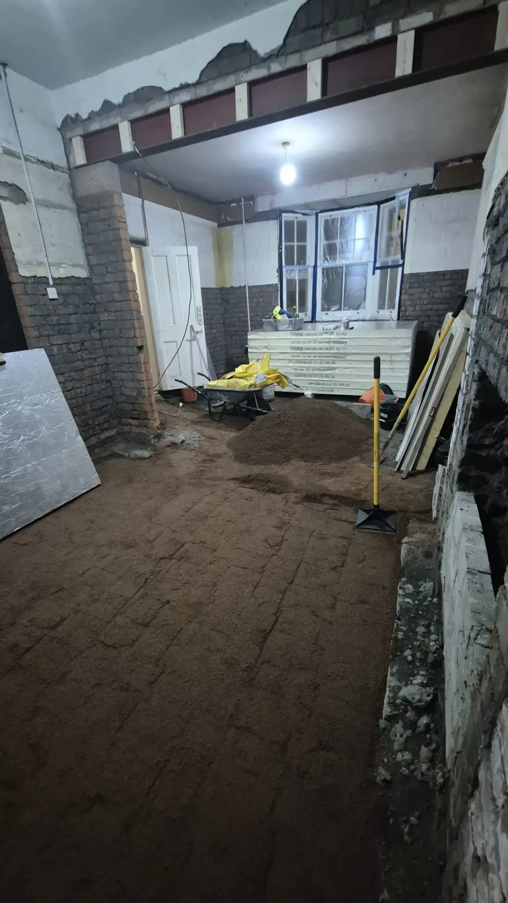 Exposed masonry, an internal beam and stacked insulation boards during the renovation.