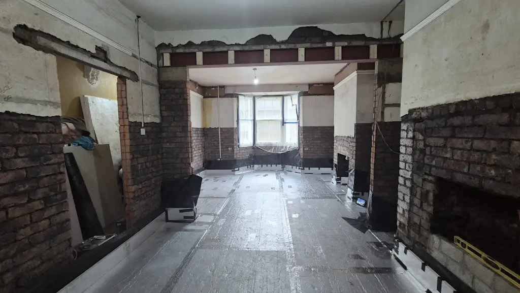 Taped foil-faced floor insulation across the front room beneath the opened-up layout.