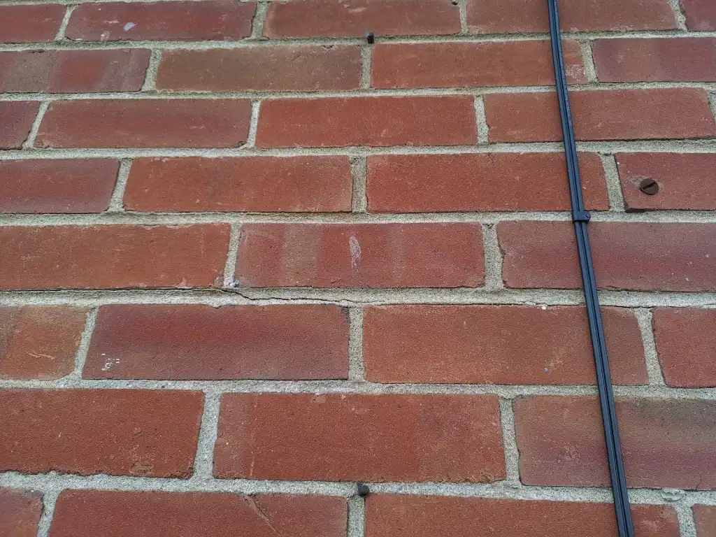 Close-up of brickwork cracking considered during wall-tie replacement work