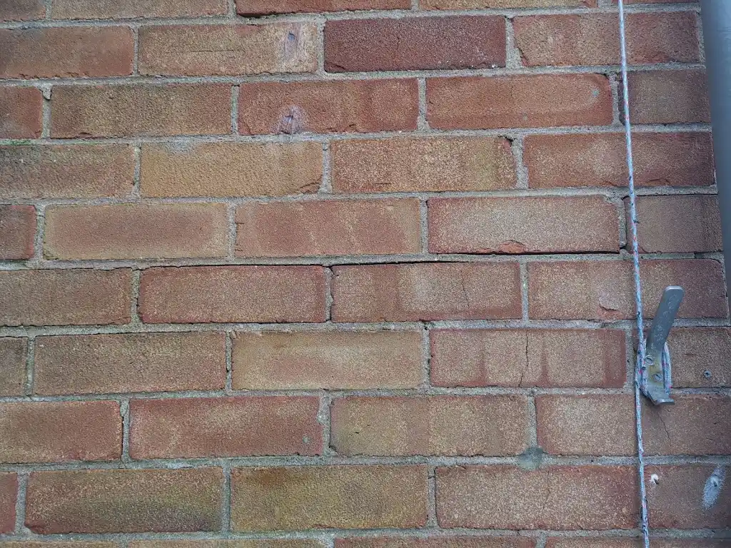 Close-up brickwork detail showing drilled wall-tie replacement location